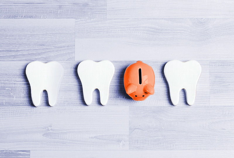 The image displays a collection of white, three-dimensional dental teeth models arranged in a row, with a red piggy bank positioned at the center.